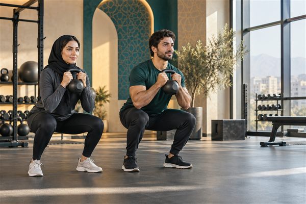 دو ورزشکار ایرانی در حال انجام حرکت اسکوات با کتل‌بل